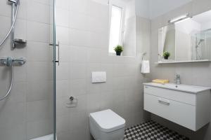 a white bathroom with a toilet and a shower at Studio Apartments River in Rijeka