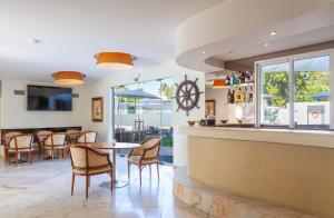 a restaurant with a bar with chairs and a table at Lagoa Hotel in Lagoa