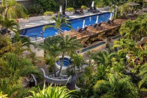 an overhead view of a resort pool with palm trees at Porto Playa Condo Hotel and Beach Club in Playa del Carmen