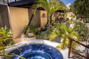 a large blue tub in a courtyard with palm trees at Porto Playa Condo Hotel and Beach Club in Playa del Carmen