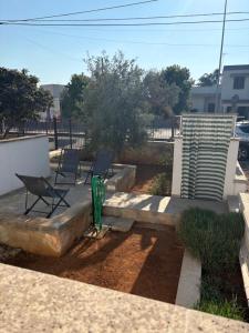 a patio with two chairs and a couple of lawn chairs at tata Uccio in Matino
