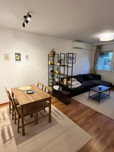 a living room with a table and a couch at Battaville Apartment in Százhalombatta
