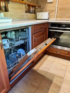 a dishwasher with its door open in a kitchen at Battaville Apartment in Százhalombatta