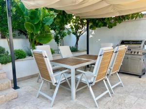 a table and chairs under an umbrella on a patio at VLATINO in Seget Vranjica