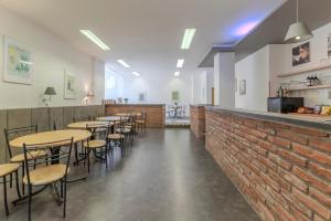 a restaurant with tables and chairs and a brick wall at Penzion Brixen in Lipnice nad Sázavou