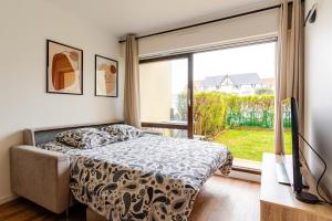a bedroom with a bed and a large window at Appartement refait à neuf, 4 pers à Courseulles in Courseulles-sur-Mer