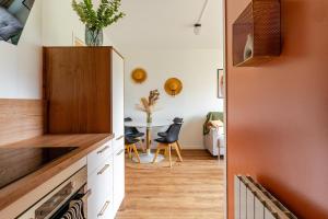 a kitchen with white cabinets and a dining room with a table at Appartement refait à neuf, 4 pers à Courseulles in Courseulles-sur-Mer