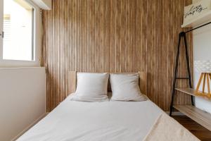 a bed with two pillows in a room at Appartement refait à neuf, 4 pers à Courseulles in Courseulles-sur-Mer