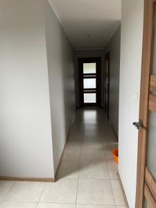 an empty hallway with a door and a tile floor at Różowa in Miłosław