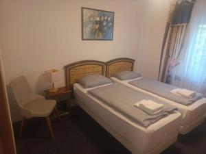 two beds in a room with a chair and a table at Werrapark Apart Heubach in Masserberg