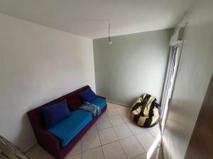 a living room with a blue couch in the corner at la vue coucher de soleil in Hauara