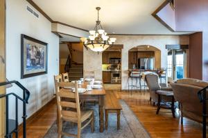 a dining room and living room with a table and chairs at Tremblant Prestige - Equinoxe 140-1 in Mont-Tremblant +32 photos
