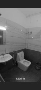 a bathroom with a toilet and a sink at Palazhi Inn in Trivandrum