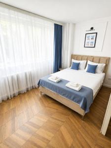 a bedroom with a large bed with blue and white pillows at Fontana Lux Apartment in Belgrade