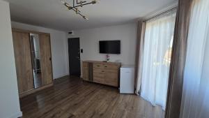 a living room with a television and a dresser with a window at Complex Casa Morii in Orăştie
