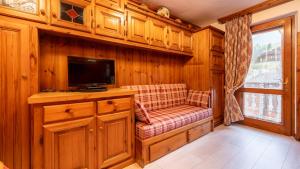 a living room with a couch and a television at Casa Amabile in Cortina dʼAmpezzo