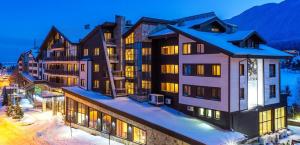 a group of buildings with snow on the ground at Pirin Getaway Heaven in Razlog