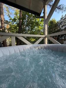 a pool of water in a backyard with a fence at Leśny Domek Rotembark z prywatnym jacuzzi in Kościerzyna