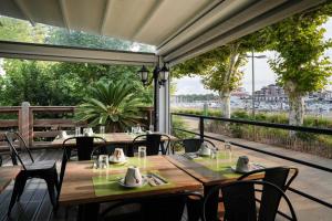a patio with tables and chairs and a view of the water at Cit'Hotel du Cap in Capbreton