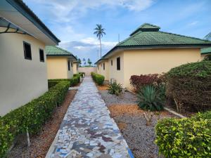 a walkway in a yard next to a house at Nima Resort et Suites in Mandanou