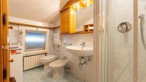 a bathroom with a sink and a toilet and a sink at Casa Amabile in Cortina dʼAmpezzo +10 photos
