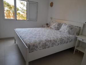 a white bedroom with a bed and a window at TORRES DEL SOL A 50 metros playa las vistas in Playa de las Americas