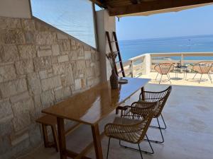a wooden table and chairs on a balcony with the ocean at Meteoron Platanias in Platanias