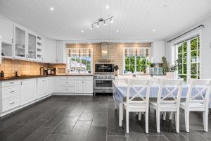 a kitchen with white cabinets and a table and chairs at Spectacular nature experience at Norway's southern point! in Svenevik