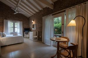 a bedroom with a bed and a table and a window at Carilo Village Apart Hotel & Spa in Carilo +78 photos