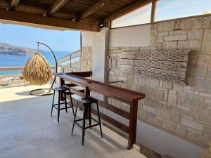 a kitchen with a table and stools on a balcony at Meteoron Platanias in Platanias