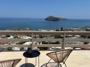 a balcony with two chairs and a view of the ocean at Meteoron Platanias in Platanias +2 photos