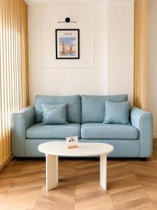 a living room with a blue couch and a white table at Fontana Lux Apartment in Belgrade