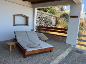 a porch with a bed and a mirror on a wall at Meteoron Platanias in Platanias