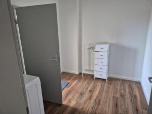 an empty room with a door and a dresser at MemaFerienwohnung in Gerolstein