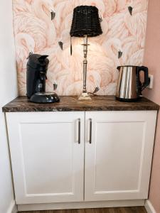 a white cabinet with a lamp on top of it at Feel-Fine Guesthouse in Nieuw-Buinen