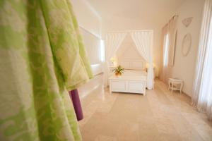 a white bedroom with a bed and a table at Antica Masseria Ficazzana - Tenuta in Marina di Pescoluse