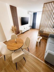 a living room with a table and chairs and a television at Fontana Lux Apartment in Belgrade +24 photos