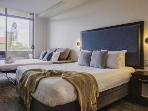 a hotel room with two beds and a large window at Mercure Centro Port Macquarie in Port Macquarie +39 photos