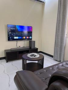 a living room with a couch and a flat screen tv at Seneu Executive Residence in Mwanza