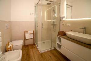 a bathroom with a shower and a sink and a toilet at Casa Delle Bollicine in Bigolino +17 photos