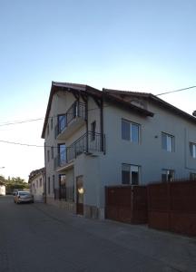 a white building with a car parked in front of it at Complex Casa Morii in Orăştie