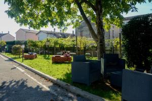 a park with chairs and a tree on the side of a street at Casa Delle Bollicine in Bigolino