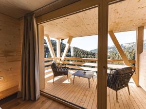 a room with a balcony with a table and chairs at Berghotel Wald&Wiesn in Balderschwang
