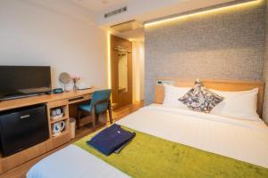 a hotel room with a bed and a television at Osaka Kansai Airport Hotel Kansai Airport 2 station in Izumi-Sano