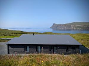 a house on a hill next to a body of water at Luxury Nordic Lodge with private Sauna in Glendale