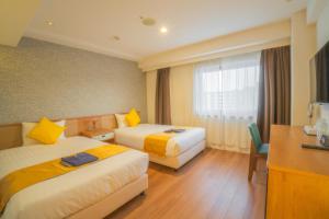 a hotel room with two beds and a desk at Osaka Kansai Airport Hotel Kansai Airport 2 station in Izumi-Sano