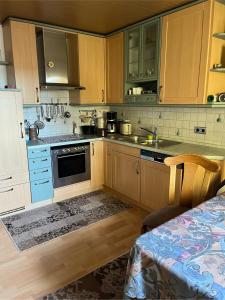 a kitchen with wooden cabinets and a sink and a stove at Haus Schneebergblick in Röslau