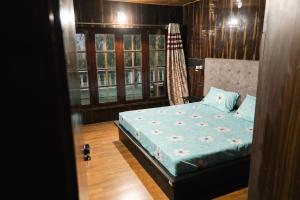 a bedroom with a bed in a room with windows at Larikha stay chumpa in Leh