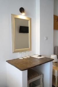 a table with glasses and a mirror on a wall at Κastro Ηotel in Agios Kirykos +233 photos