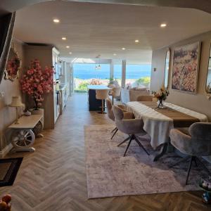 a dining room with a table and chairs and the ocean at Sunrise view in Ballina